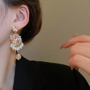 Close-up of vintage butterfly earrings with champagne crystal drop and bead details