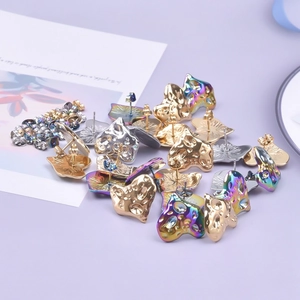 Detailed macro view of heart-shaped stainless steel studs with hammered texture in multiple colors