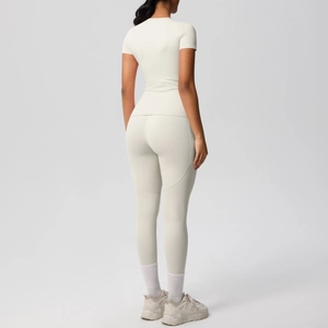 Detail view of cream white high-waist yoga leggings and slim fit short sleeve top