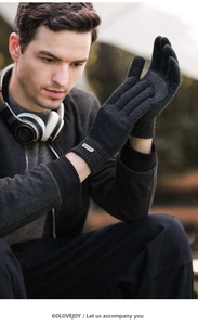 Close-up of warm winter knit gloves with non-slip grip and branded tag in dark grey