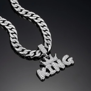 Close-up of iced out silver KING crown pendant on a thick Cuban link chain