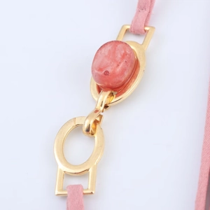 Macro detail of pink agate texture with gold metal buckle and pink textile cord