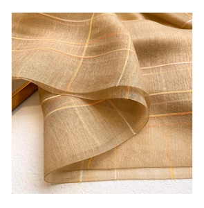 Close-up of golden checkered silk wool fabric showing delicate sheer texture and shine
