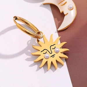 Detailed close-up of 18K gold-plated sun and moon earrings with pearl accents