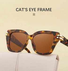 Cat-Eye-Sonnenbrille in Schildpatt mit braunen Gläsern auf einem Lederetui präsentiert