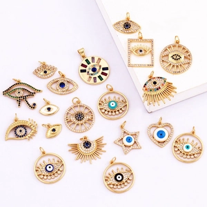 Macro shot of assorted golden Evil Eye charms with colorful crystals on a white surface