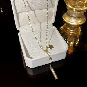 Elegant gold star pendant necklace with mother-of-pearl bar on luxury display box