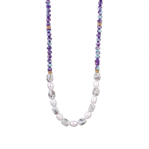 Detail of beaded necklace with purple stone cubes, white pearls and gold metal spacers