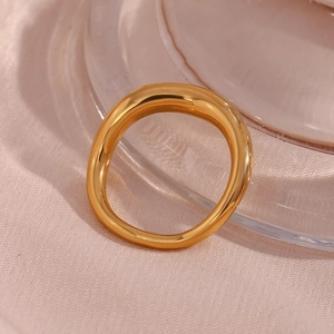 Close-up of chunky irregular gold plated stainless steel ring on a soft pink fabric