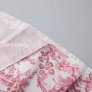 Gros plan d'un motif floral à l'encre sur tissu blanc avec couture de bordure précise