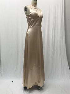 Détail d'une robe de soirée élégante en satin champagne avec col en V et texture soyeuse