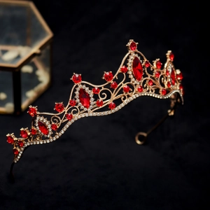 Close-up of golden crown with marquise-cut red gemstones and intricate镂空 detailing