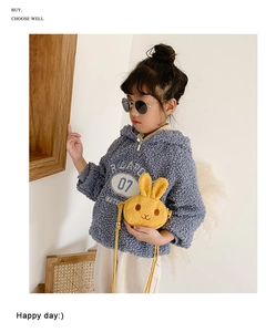 Detail of a child's yellow plush bunny crossbody bag paired with a blue hoodie