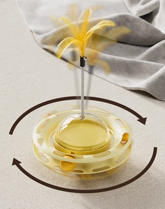 Close-up of yellow tumbler cat toy with rotating track ball and spring feather teaser