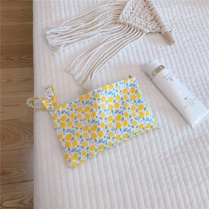Close-up of small floral cotton pouch with lemon print and side wristlet strap