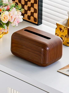 Detailed view of dark walnut wood grain texture on a modern rectangular tissue box