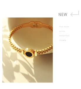 Dettaglio del bracciale placcato oro 18K con disco nero, numeri romani e incisione