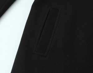 Close-up of pocket stitching and fiber texture on black wool blend short coat