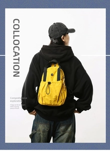 Fashionable bright yellow lightweight nylon backpack shown on model with minimalist white background