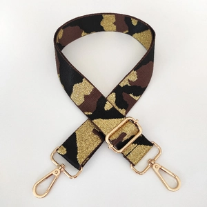 Close-up of wide camouflage bag strap with premium gold metal hooks and adjustable buckle