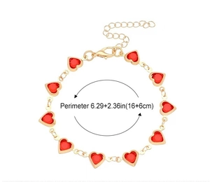 Detail showing the adjustable lobster clasp and red heart gemstone size of the gold bracelet