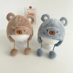 Dettaglio di berretti in peluche per neonati con orecchie di orso e pompon in kaki e grigio
