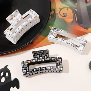 Macro shot of Halloween claw clips featuring spooky pumpkin, ghost, and skull patterns