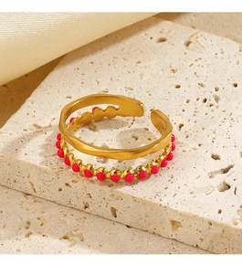 Close-up of double layer gold ring with pink bead detail on a natural stone base