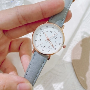 Detailed shot of a women's quartz watch featuring a grey suede strap and rose gold case