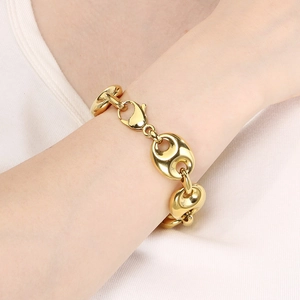 Detail of 18k gold plated stainless steel pig nose chain bracelet worn on a female wrist