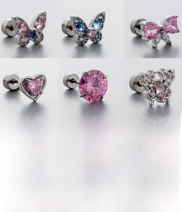 Détail macro de boucles d'oreilles papillon avec cœur en zircon rose et tige en titane