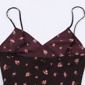 Détail du décolleté en V et de l'imprimé fleuri de cette robe midi bordeaux