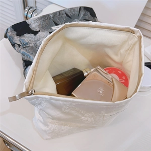 Interior detail of jacquard makeup bags showing storage capacity for cosmetics and skincare