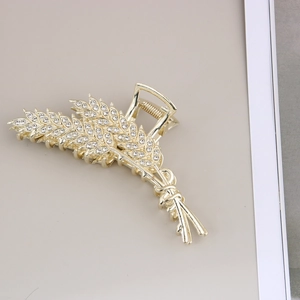Détail de la pince à cheveux en métal doré avec motif de feuilles de blé en strass