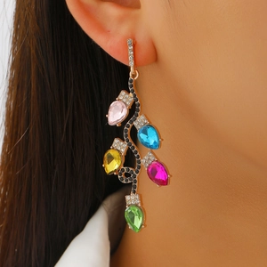 Gros plan de boucles d'oreilles de Noël avec cristaux de couleur en forme de goutte