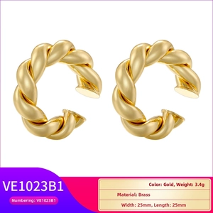 Detail showing high-polish gold braided brass hoop earrings with elegant twisted texture