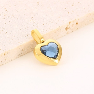 Macro shot of heart-shaped blue faceted crystal pendant with gold metal border