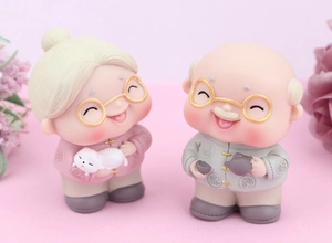 Close-up of cute elderly couple cake topper figurines with traditional Chinese attire