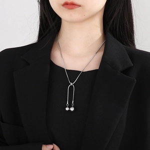Silver bead pendant snake chain necklace on model wearing a black blazer jacket