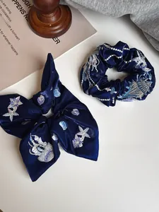 Detailed embroidery of seashells and starfish on a premium navy satin silk hair scrunchie