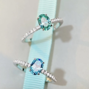 Macro shot of oval-cut Paraiba gemstone rings with diamond-encrusted silver bands