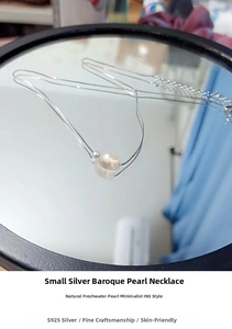 Detailed macro view of S925 silver chain with baroque pearl and polished silver bead pendant