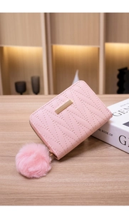 Detailed view of a pink faux leather short wallet featuring a matching plush ball pendant