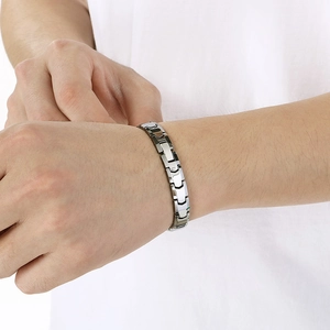 Gros plan d'un bracelet pour homme en acier inoxydable argenté poli porté au poignet