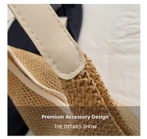 Close-up of woven straw tote bag with cream leather strap and fine stitching details