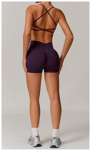 Detail of high-waist scrunch butt shorts and cross-back sports bra in dark purple