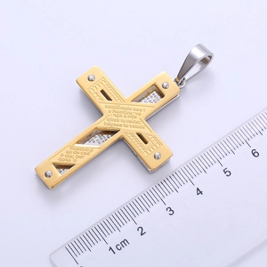 Macro detail of gold and silver cross pendant with Spanish scripture and size ruler