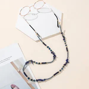 Detailed macro view of blue beads, crushed stones, and gold accents on an eyewear chain