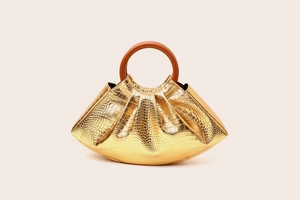 Detail of gold pleated cloud bag with crocodile texture and brown round handle