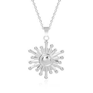Macro view of silver stainless steel sun pendant with 18k plating on a white background